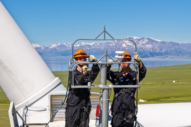 图为检修人员维护风机风速仪