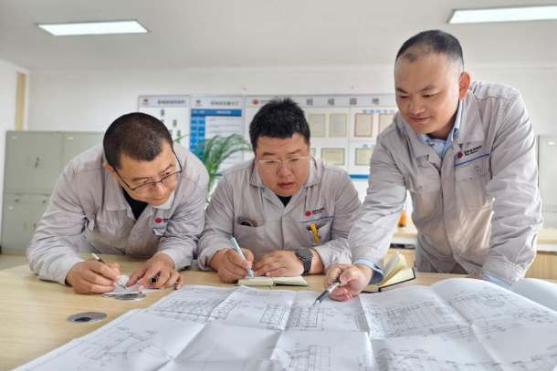 1758523174352016551.jpg 图为配电班QC小组成员研究专用试验装置工艺图纸.jpg